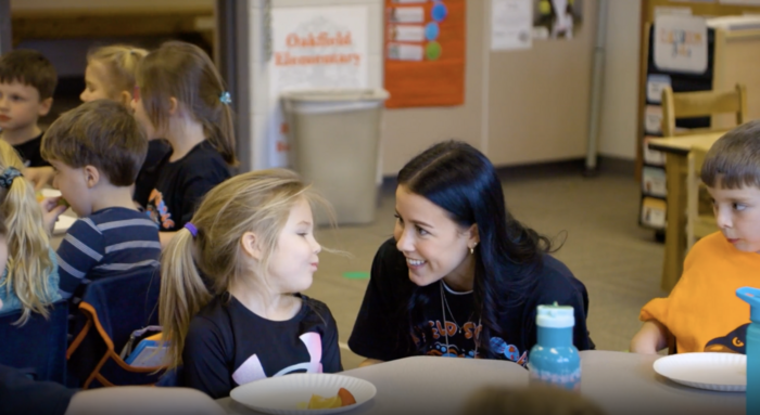 Smiling teacher with girl at table