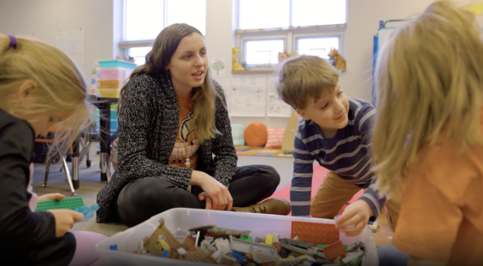 Teacher on floor playing with 4K students