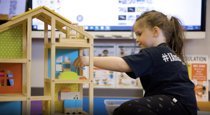 Girl playing with dollhouse